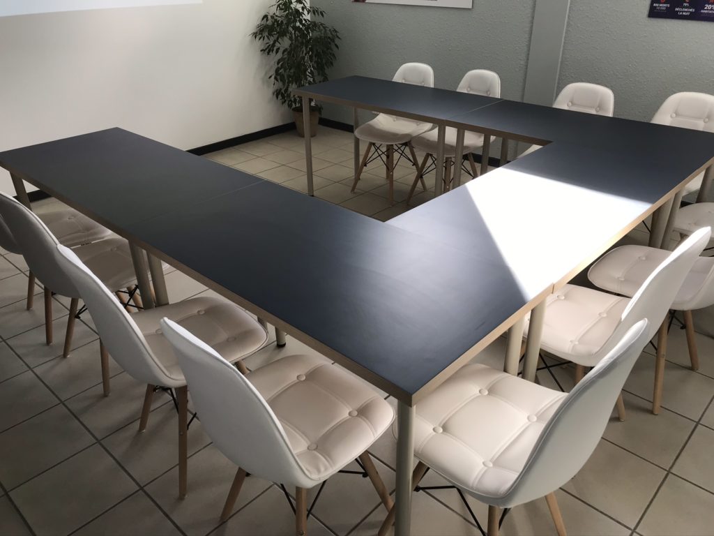 chaises blanches tables noires en U