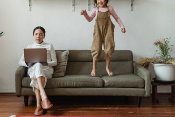 enfants et femme sur un canapé. la femme fait du télé-travail